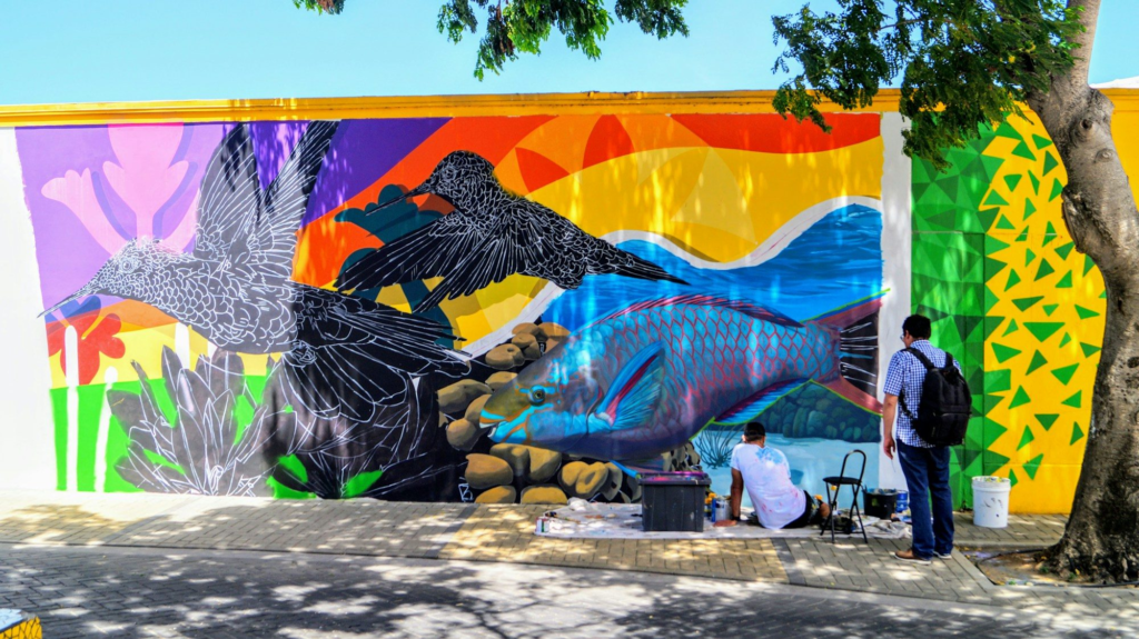 Couple looking at a bird mural in San Nicolas, Aruba