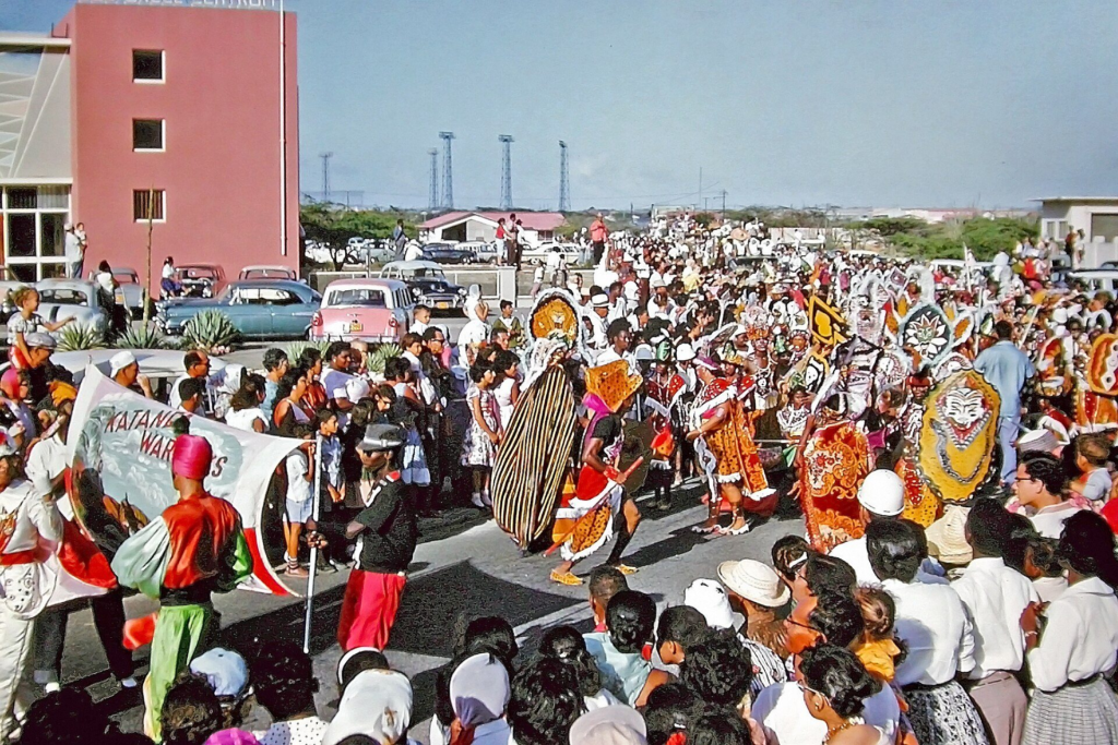 Crowds lining a street for a Carnival parade in Aruba, 1961