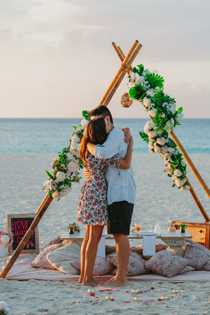 A couple embracing on an Aruba beach after a proposal