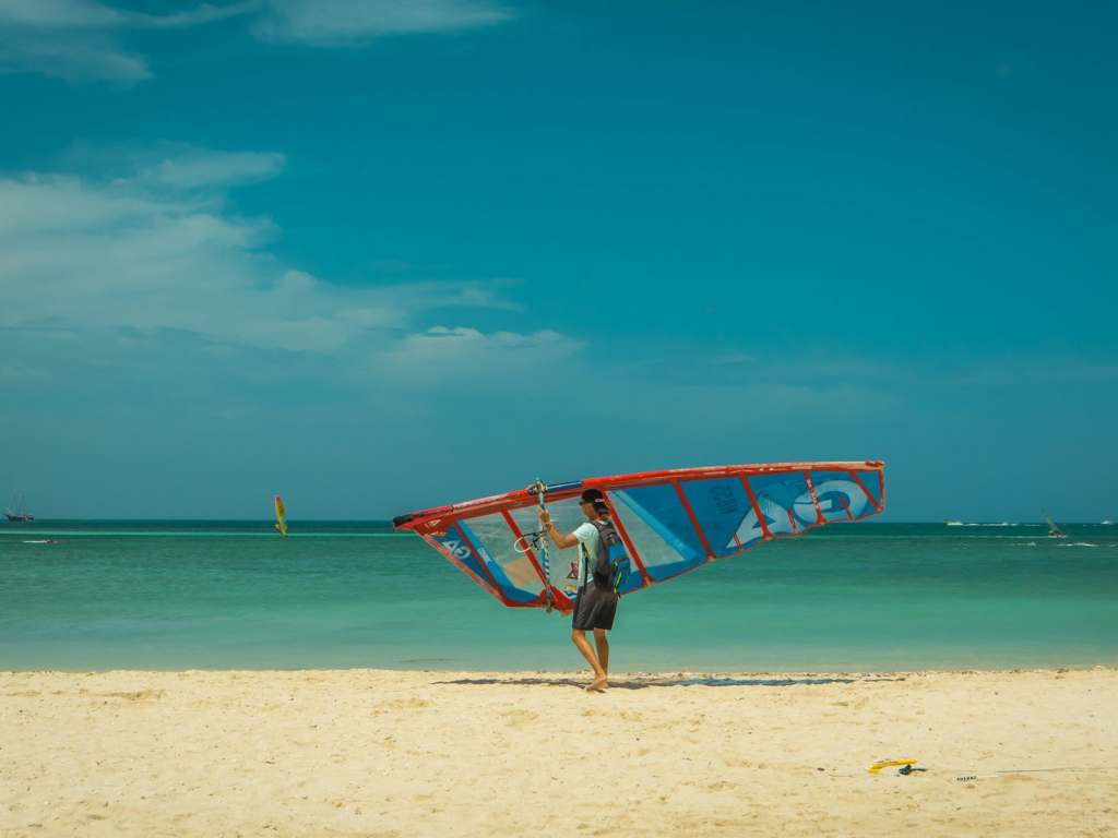 Kitesurfer holding a kite on a windy beach in Aruba during Hi-Winds