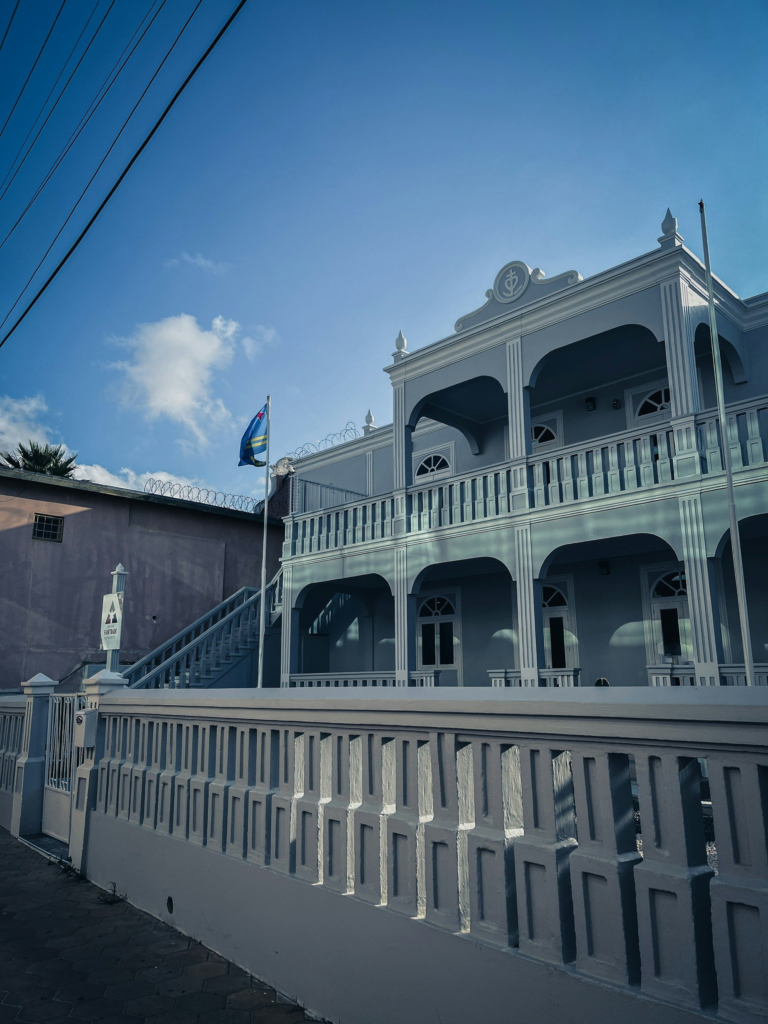 White colonial-style building with a clock tower in Oranjestad, Aruba
