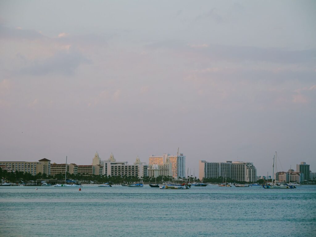 Coastal Oranjestad at twilight, with boats and buildings along the shore