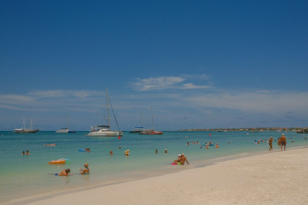 Swimmers relaxing in calm, clear turquoise water in Aruba