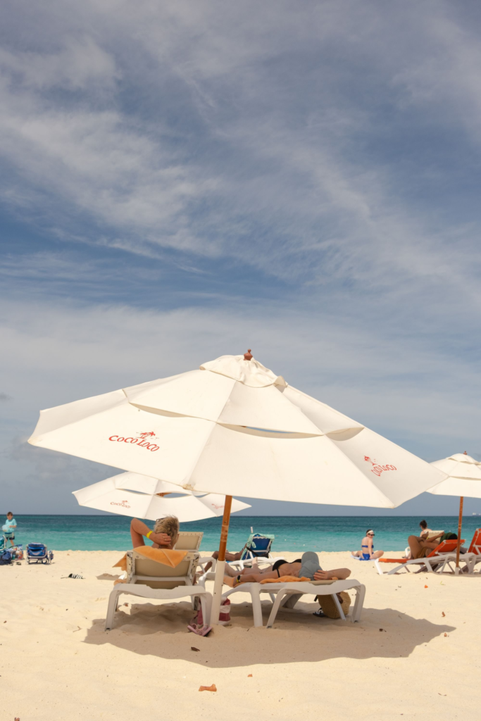 White parasols and visitors on the sand at Eagle Beach, Aruba