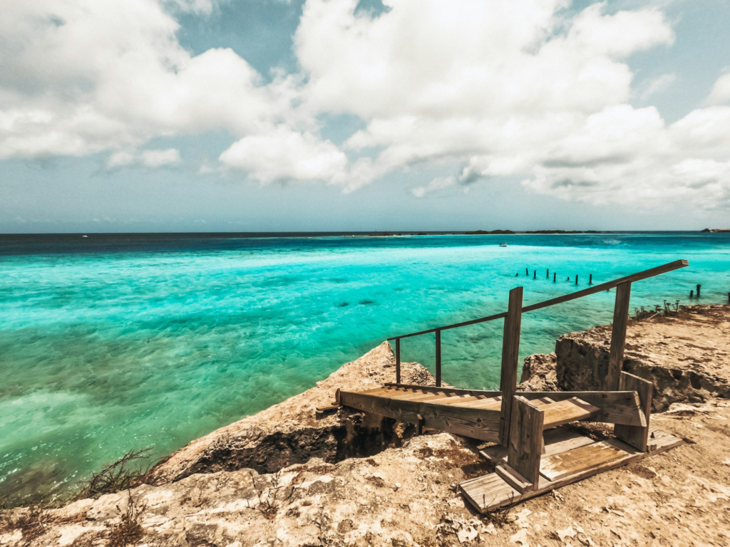 Steps leading down to clear blue water on Aruba's coast