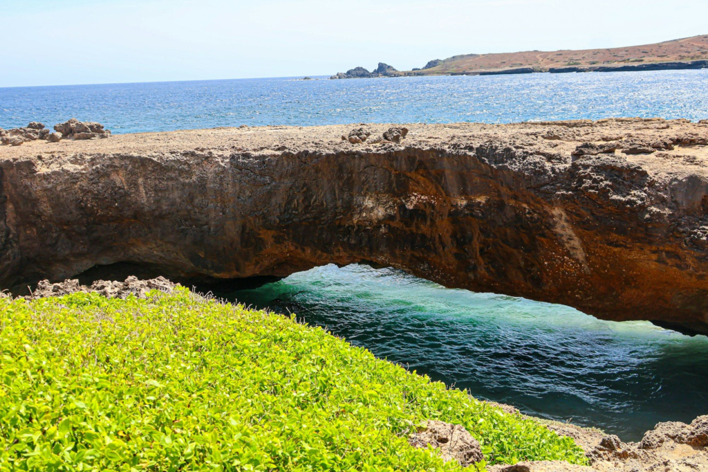 Rock arch over turquoise water near the Natural Bridge site, Aruba