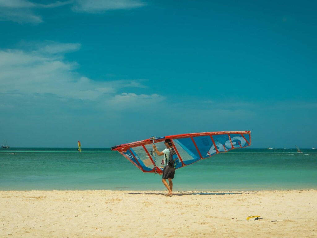 Windsurfer carrying a sail on the beach during Aruba Hi-Winds