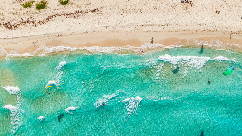 Aerial view of people swimming in turquoise water off San Nicolas, Aruba